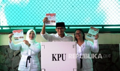  Cawagub Sandiaga Uno bersama keluarga menunjukkan surat suara saat akan pencoblosan di TPS 01 kawasan Senayan, Jakarta, Rabu (19\4).