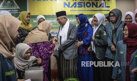 Cawapres nomor urut 01 Ma'ruf Amin (tengah) didampingi istrinya Wuri Estu Handayani (keempat kanan) berjabat tangan dengan pelajar putri saat menghadiri Rapat Pimpinan Nasional (Rapimnas) Pimpinan Pusat Ikatan Pelajar Putri Nahdlatul Ulama (PP IPPNU) di Jakarta, Ahad (7/10).