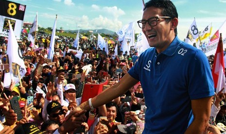 Cawapres nomor urut 02 Sandiaga Uno (kanan) menyalami pendukungnya saat kampanye terbuka di Lapangan Jalan Lingkar Selatan, Cilegon, Banten, Sabtu (30/3/2019). 