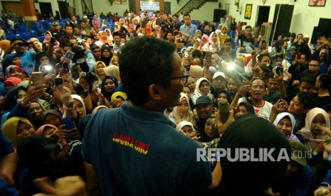 Cawapres nomor urut 02 Sandiaga Uno (tengah) bernyanyi saat menghadiri dialog bersama milenial dan emak-emak di Tegal, Jawa Tengah, Senin (11/2/2019).