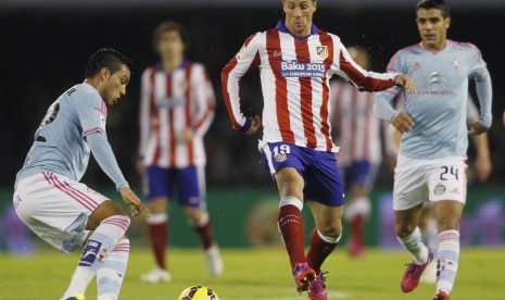 Celta Vigo's Augusto Fernandez (R) and Gustavo Cabral (L) fight for the ball with Atletico Madrid's Fernando Torres during their Spanish first division soccer match at the Balaidos stadium in Vigo February 15, 2015