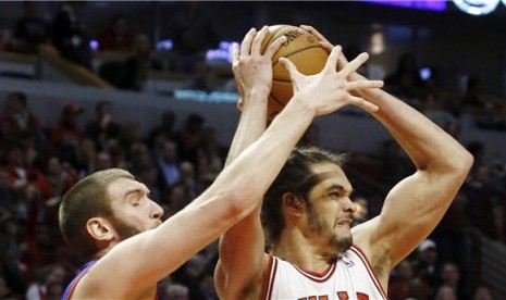 Center Chicago Bulls, Joakim Noah (kanan), berebut bola dengan center Philadelphia 76ers, Spencer Hawes, di laga NBA di Chicago pada Kamis (28/2). 