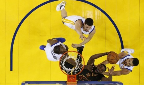 Center Cleveland Cavaliers Tristan Thompson hendak memasukkan bola, dijaga oleh tiga pemain Golden State Warriors pada gim kedua final NBA 2017.