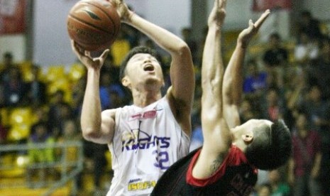 Center CLS Knights Herman (kiri) berusaha memasukkan bola dijaga oleh forward Garuda Christ Gideon dalam lanjutan NBL Indonesia Seri II Bandung, Sabtu (13/12).