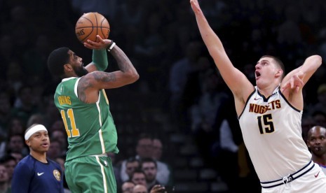 Center Denver Nuggets Nikola Jokic berusaha menghalangi guard Boston Celtics Kyrie Irving menembak.