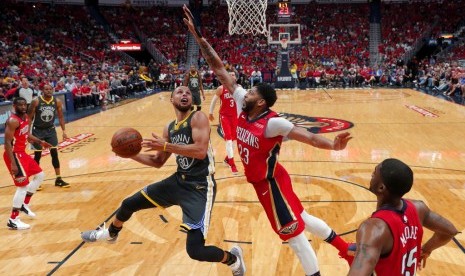 Center New Orleans Pelicans, Anthony Davis (tengah) mengadang guard Golden State Warriors, Stephen Curry (kiri) pada laga gim ketiga semifinal playoff wilayah Barat NBA, di Smoothie King Center, Sabtu (5/5) pagi WIB. Pelicans menang 119-100.