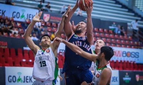 Center Pelita Jaya Adhi Pratama berusaha memasukkan bola dijaga para pemain Pacific Caesar pada turnamen pramusim IBL Gojek 2018.