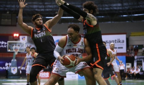 Center Pelita Jaya Bakrie Dior Lowhorn memegang bola dijaga dua pemain NSH Jakarta pada laga Seri IV IBL Pertamax 2020.