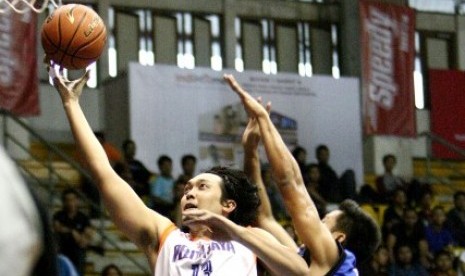 Center Pelita Jaya Ponsianus Nyoman 'Komink' Indrawan memasukkan bola saat menghadapi Satya Wacana dalam lanjutan NBL Seri II Bandung, Sabtu (13/12).