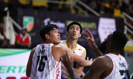 Center Satria Muda Pertamina Christian Ronaldo Sitepu dijaga center Bima Perkasa Jogja, Frida Aris Susanto pada pertandingan IBL Pertalite Seri I di GOR Sahabat, Semarang, Sabtu (9/12).