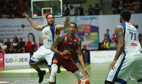 Center Satria Muda Pertamina Dior Lowhorn menjaga pemain Hangtuah Nahshon George (tengah) dalam pertandingan IBL Pertalite di GOR UNY Yogyakarta, Ahad (28/1).