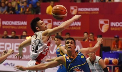 Center Satria Muda Pertamina Kevin Yonas (biru) berebut bola dengan center Aspac Ferdinand Damanik dalam pertandingan IBL di Jakarta, Sabtu (9/1).