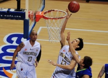 Center tim basket Indonesia, Rony Gunawan, berusaha melakukan lay up melewati hadangan pebasket Malaysia dalam laga kejuaraan South East Asia Basketball Association (SEABA) 2011, di Britama Arena Sportmall, Jakarta, Sabtu (25/6).