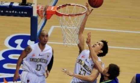 Center tim basket Indonesia, Rony Gunawan, berusaha melakukan lay up melewati hadangan pebasket Malaysia dalam laga kejuaraan South East Asia Basketball Association (SEABA) 2011, di Britama Arena Sportmall, Jakarta, Sabtu (25/6).