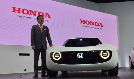 CEO Honda Motor Co Takahiro Hachigo berdiri di sebelah Honda Sport EV Concept saat diperkenalkan untuk pertama kali di ajang Tokyo Motor Show 2017 di Tokyo, Rabu (25/10).