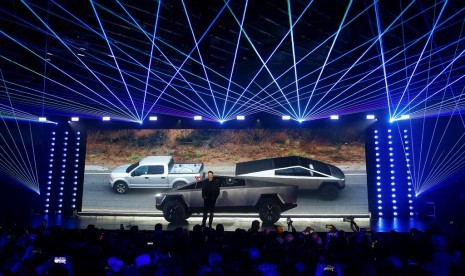 CEO Tesla Elon Musk mengenalkan Tesla Cybertruck di California. Tampak di belakang latar foto Cybertruck menarik mobil Ford. 