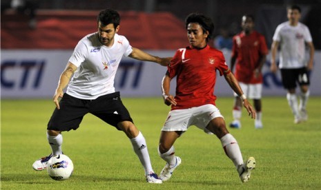 Cesc Fabregas (kiri) berebut bola dengan pesepakbola Indonesia, Taufiq, pada laga eksibisi 'Fabregas and Friends' lawan 'Tim Garuda' di Stadion Utama Gelora Bung Karno, Senayan, Jakarta, Kamis (5/7). 