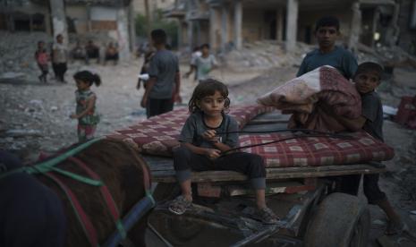  Chadi Nassir, 7, duduk di atas gerobak keledai ketika saudaranya, Mahmoud, memuatnya dengan barang-barang dari rumah mereka yang rusak di Beit Hanoun, Jalur Gaza utara, Minggu, 13 Juni 2021.