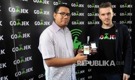 Chief Marketing Officer Go-Jek Indonesia, Piotr Jakubowski (kanan) bersama Chief Executive Officer Rumah Zakat (kiri) menunjukan aplikasi GO-SENT, GO-BOX dan GO-TIX saat program Ramadan bersama GO-JEK di Jakarta, Rabu (8/6). 