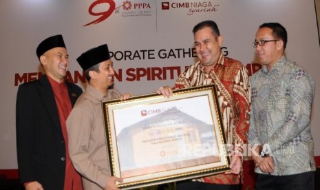  Chief Syariah Banking CIMB Niaga Pandji P Djajanegara (kedua kanan) menyerahkan donasi kepada Dewan Pembina PPPA Darul Quran Yusuf Mansur pada acara Corporate Gathering bertajuk Membangun Spiritual Company di Jakarta, Rabu (13/4).(Republika/Darmawan)