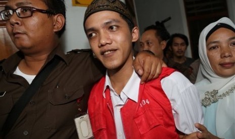 Child sexual abuse suspect Agun Iskandar, center, is escorted by security officers after his trial at South Jakarta District Court in Jakarta, Indonesia, Monday, Dec. 22, 2014. 