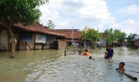 Children play at the inundated area nearby their houses in Mijen, Demak, Central Java, on Sunday.