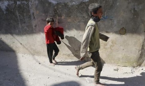 Children react after losing their mother in what activists said where explosive barrels thrown by forces loyal to Syrian President Bashar al-Assad in the Al-Andhirat neighbourhood of Aleppo February 22, 2014.