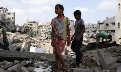 Children stand amid the ruins of their family's apartment that witnesses say was destroyed by Israeli air strikes in the Shejaia neighbourhood in Gaza City August 12, 2014.