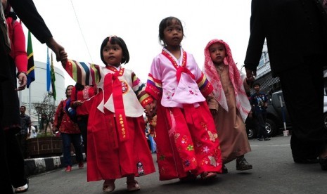 Children wears traditional dress of Korea and Saudi Arabia during a carnival in the opening of 58th Anniversary of Asian African Conference (KAA) in Bandung, West Java, on Thursday.  