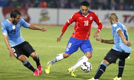 Chilean defender Gonzalo Jara (C) fights for the ball with Uruguayan midfielder Carlos Sanchez (R) and Uruguayan midfielder Alvaro Gonzalez during the Copa America 2015 quarter-finals soccer match between Chile and Uruguay, at Estadio Nacional Julio Martin