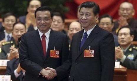 China's President Xi Jinping shakes hands with China's newly elected Premier Li Keqiang (left) as other delegates clap during the fifth plenary meeting of the first session of the 12th National People's Congress (NPC) in Beijing March 15, 2013. 