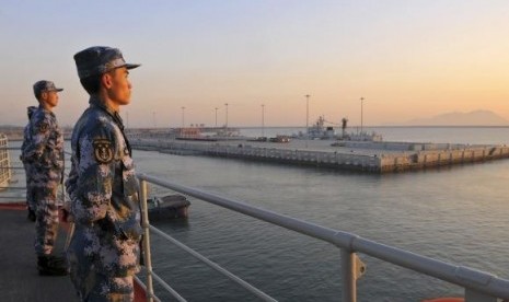 Chinese naval soldiers stand guard on China's first aircraft carrier Liaoning, as it travels towards a military base in Sanya, Hainan province, in this undated picture made available on November 30, 2013.