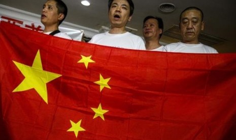 Chinese relatives of passengers onboard the missing Malaysia Airlines flight MH370 hold China's national flag during a news conference at The Holiday Villa in Subang Jaya March 30, 2014.