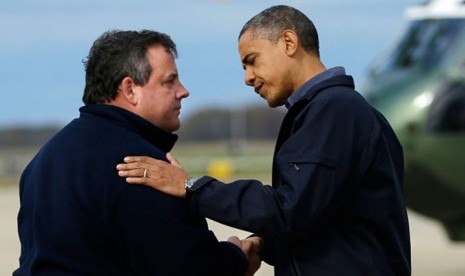 Chris Christie (kiri) menyambut kedatangan Presiden Barack Obama di New Jersey.