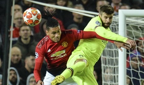 Chris Smalling (kiri) berduel bola dengan Gerard Pique.