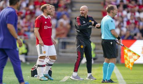  Christian Eriksen dari Manchester United, kedua dari kiri, bersiap untuk bermain saat dia berbicara dengan pelatih Erik ten Hag, selama pertandingan persahabatan antara Atletico Madrid dan Manchester United di stadion Ullevaal, di Oslo, Sabtu, 30 Juli 2022.