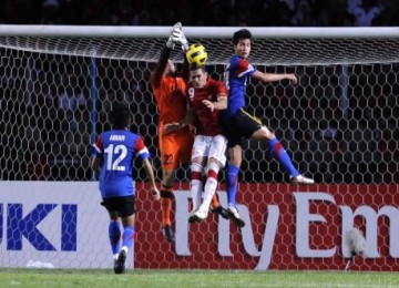 Christian Gonzales diapit kiper dan pemain Malaysia di laga final leg kedua, Rabu (29/12).