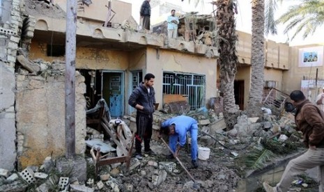 Civilians sift through rubble and stand in the ruins of a home after a car bomb attack in the Shula neighborhood in Baghdad, Iraq, Thursday, Jan. 30, 2014. 