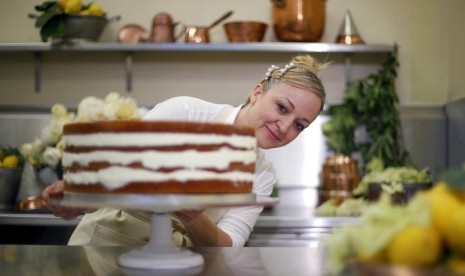 Claire Ptak pemilik Violet Bakery London berpose di samping kue pengantin yang sedang digarap untuk Pangeran Harry dan Meghan Markle.