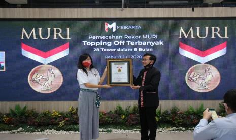 CMO Meikarta Lilies Surjono (kiri) menerima penghargaan dari Senior Manager MURI Jusuf Ngadri di District 1 Meikarta, Cikarang, Bekasi (8/7). Penghargaan yang diterima berupa Topping-Off terbanyak yakni 28 tower dalam waktu kurang dari setahun.