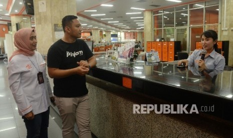 Co-Founder dan Chief Executive Officer Pinjam.co.id Teguh Ariwibowo (kedua kanan), bersama Direktur Ritel dan SDM PT Pos Indonesia Ira Puspadewi (kiri) mendengarkan penjelasan dari karyawan tentang layanan gadai antara Pinjam.co.id dengan PT Pos Indonesia di kantor Pos Pusat, Jakarta, Rabu (25/10).