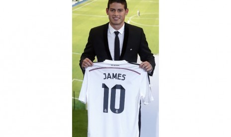 Colombia's soccer player James Rodriguez holds up his new Real Madrid jersey during a presentation at the Santiago Bernabeu stadium in Madrid, July 22, 2014. Real Madrid have signed Rodriguez from Monaco on a six-year contract, the La Liga club said on Tue