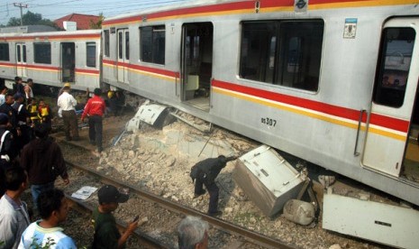 COMMUTER LINE ANJLOK. Sejumlah petugas melakukan pemeriksaan sebelum melakukan evakuasi gerbong KRL Commuter Line Jurusan Bogor-Jakarta Kota yang anjlok dan menabrak pembatas rel di Stasiun Cilebut, Bogor, Jabar, Kamis (4/10).