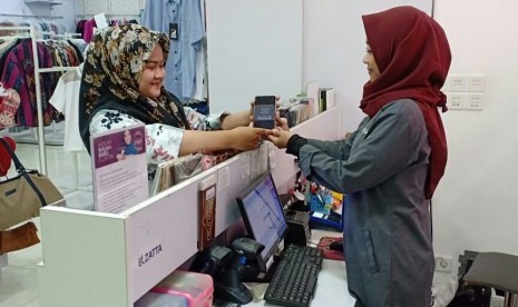  Costumer Elzatta menunjukkan barcode tanda mendapatkan diskon 20 persen atas pembelian produk di Toko Elzatta and Dauky.    