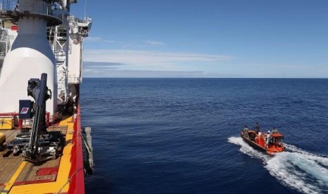 Crew members are seen aboard a fast response craft (right) from the Australian Defence Vessel Ocean Shield (left) as they continue to search for debris of the missing Malaysian Airlines flight MH370 in the Southern Indian Ocean on April 8, 2014.