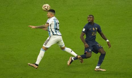  Cristian Romero dari Argentina (kiri) menyundul bola melewati Marcus Thuram dari Prancis selama pertandingan sepak bola final Piala Dunia antara Argentina dan Prancis di Stadion Lusail di Lusail, Qatar, Ahad (18/12/2022). Romero adalah pemain Tottenham yang berjaya di Qatar.