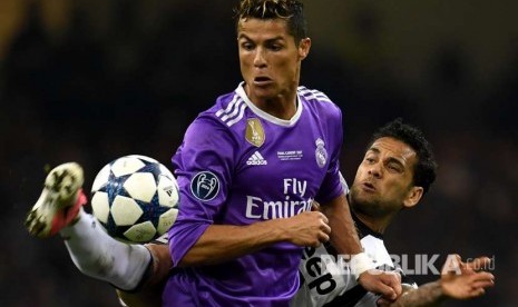 Cristiano Ronaldo (depan) dan Dani Alves berebut  bola. 