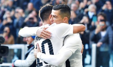 Cristiano Ronaldo (kanan) merayakan gol Juventus bersama Paulo Dybala pada laga Serie A lawan Sampdoria, Sabtu (29/12).