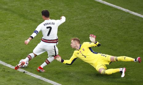 Cristiano Ronaldo (kiri) dari Portugal mencetak keunggulan 3-0 melawan kiper Hongaria Peter Gulacsi (kanan) pada pertandingan sepak bola babak penyisihan grup F UEFA EURO 2020 antara Hongaria dan Portugal di Budapest, Hongaria, 15 Juni 2021.