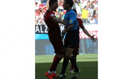 Cristiano Ronaldo (kiri) dengan wasit Milorad MAZIC dari Serbia selama dipertandingan antara Jerman dan Portugal di Arena Fonte Nova di Salvador, Brasil, Senin (16/6).   ( EPA / Ali Haider).